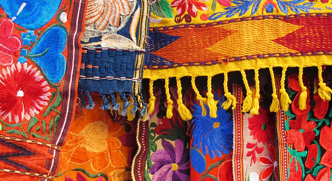 a photo of different colored flags and scarfs that represent the many hispanic and latino countries.